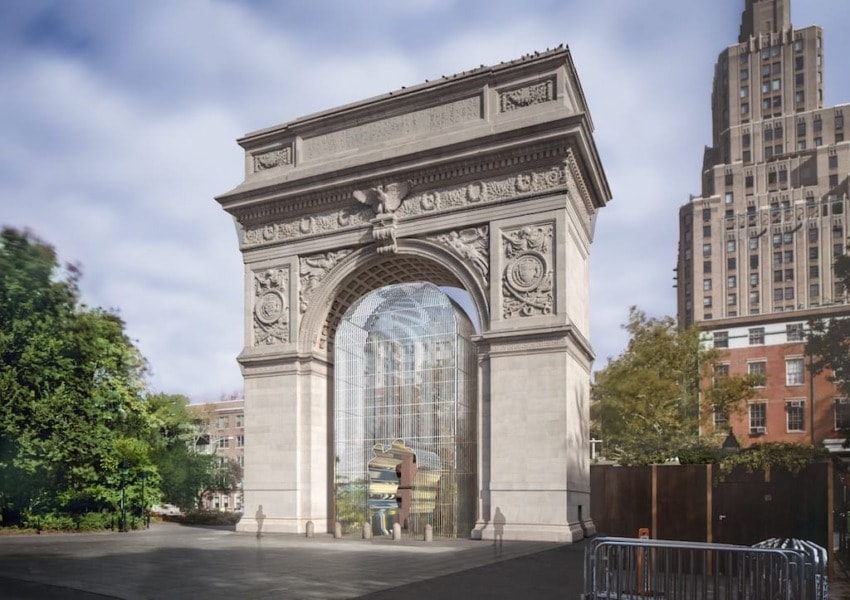 The Washington Square Arch in New York City framed by trees and a tall building in the background on a sunny day.