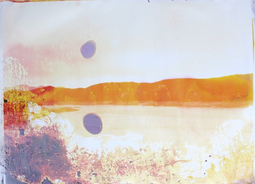 Abstract landscape with warm orange hues, resembling mountains and a river, featuring two circular marks.
