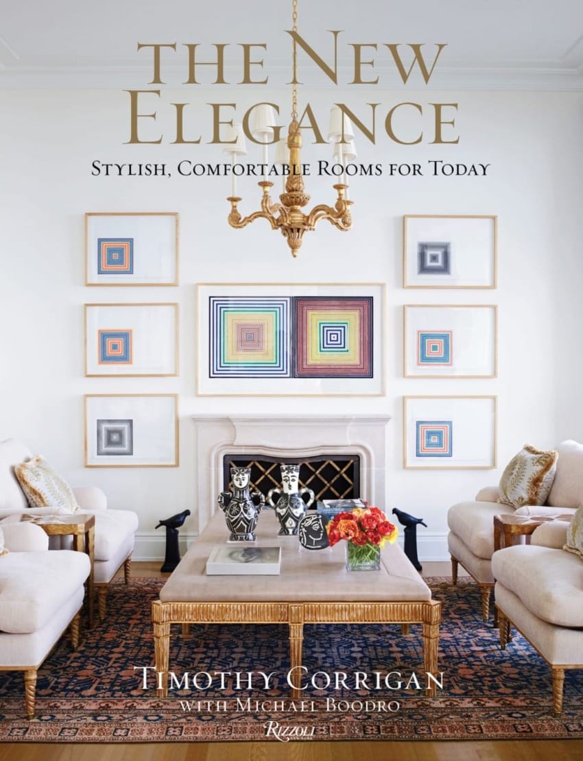 Cover of "The New Elegance" showcasing an elegant living room with framed geometric art and a central chandelier.