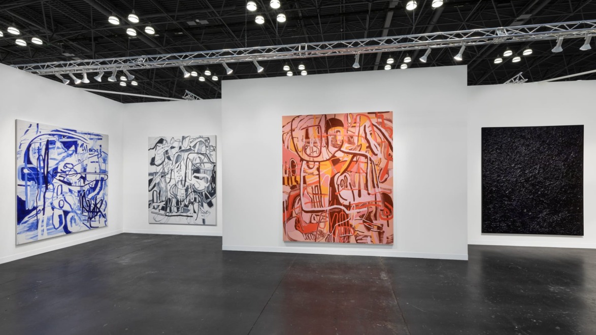 Art gallery exhibition featuring four abstract paintings in a well-lit modern space with concrete floors and high ceilings.