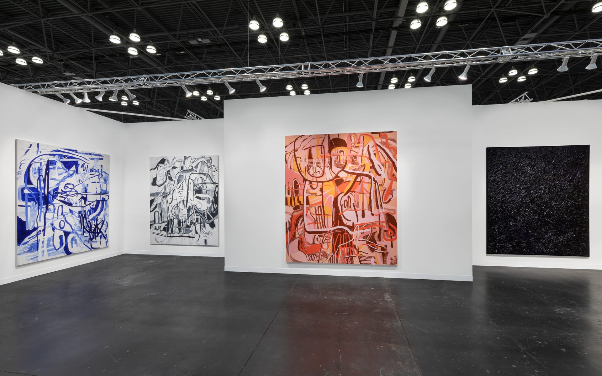 Art gallery exhibition featuring four abstract paintings in a well-lit modern space with concrete floors and high ceilings.