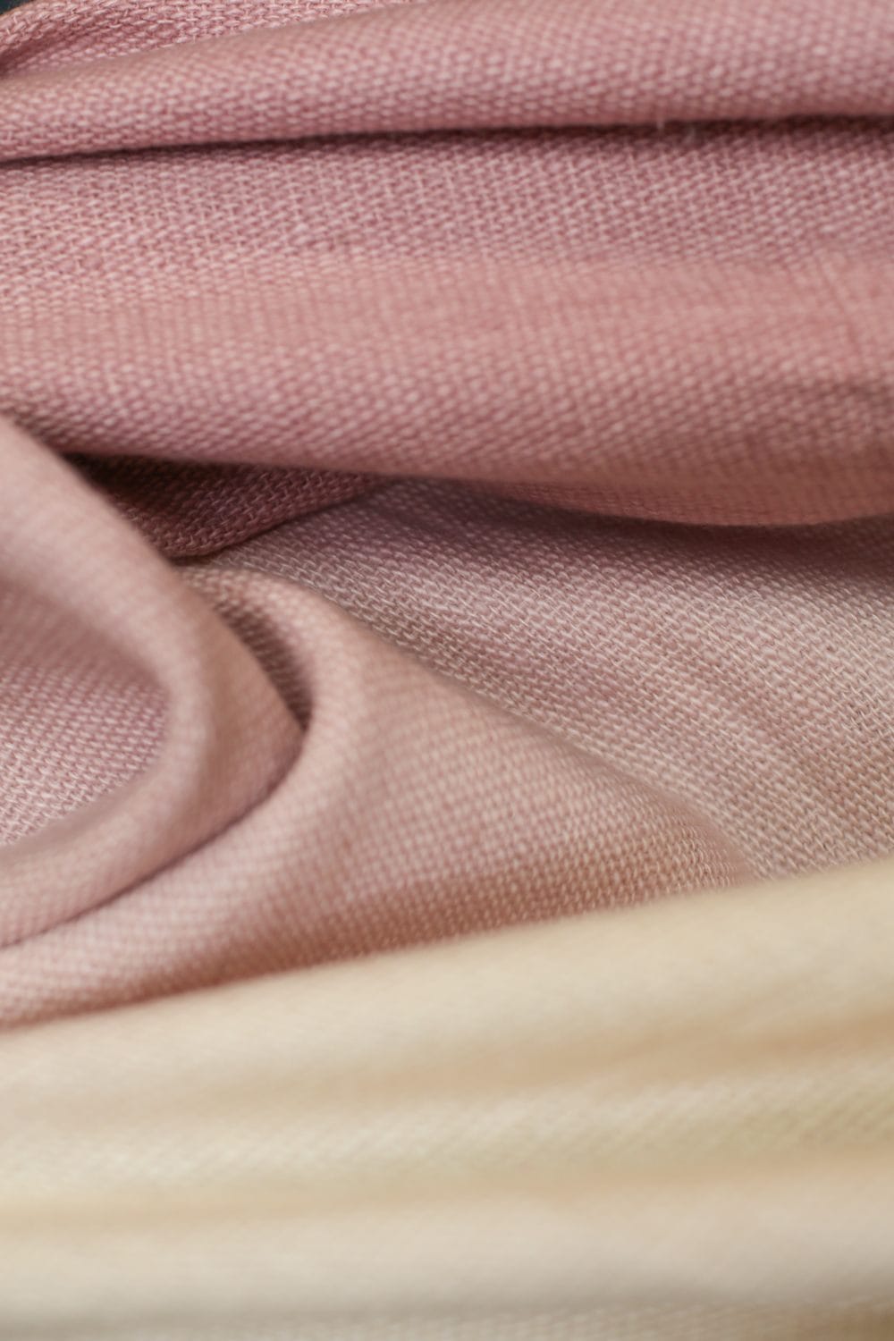 Close-up of soft, pink and beige folded fabric texture.