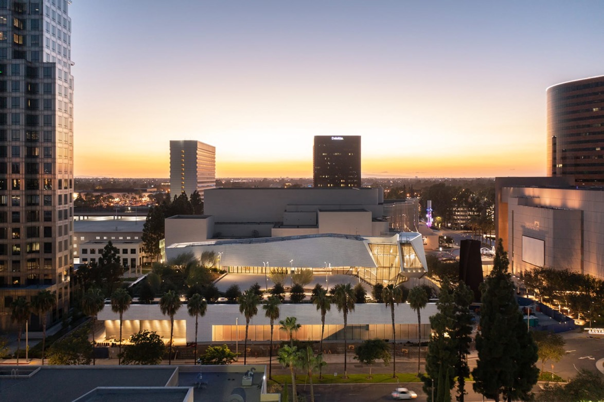 Orange County Museum of Art at dusk with cityscape and illuminated building.