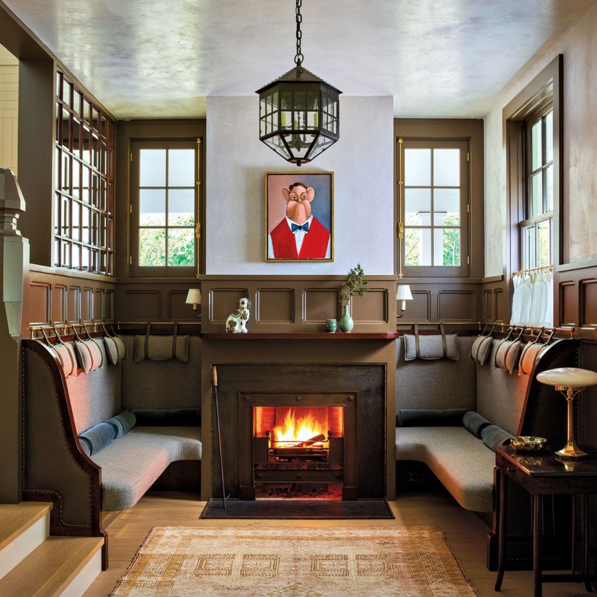 Cozy living room with a modern fireplace, U-shaped seating, artwork above mantel, and warm, inviting atmosphere.