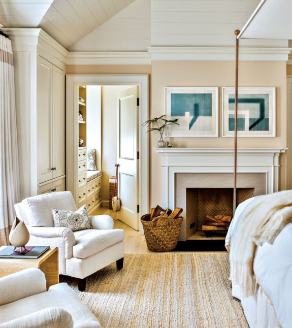 Cozy living room with armchair, fireplace, art on wall, and open door to storage space with shelves.