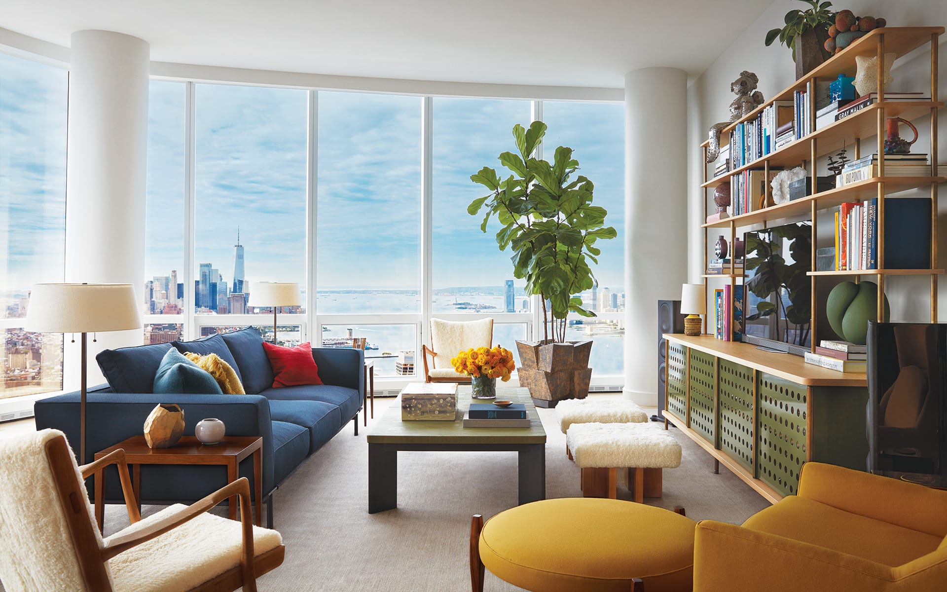A pair of Hans Wegner armchairs bookend a Molteni&C sofa upholstered in a Maharam fabric and facing a midcentury-modern-style cabinet by Fort Standard in this penthouse by Shawn Henderson.