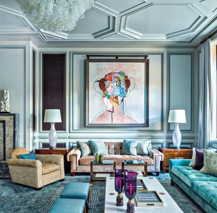 Elegant living room with modern art, plush sofas, decorative ceiling, large windows, and eclectic lighting fixtures.
