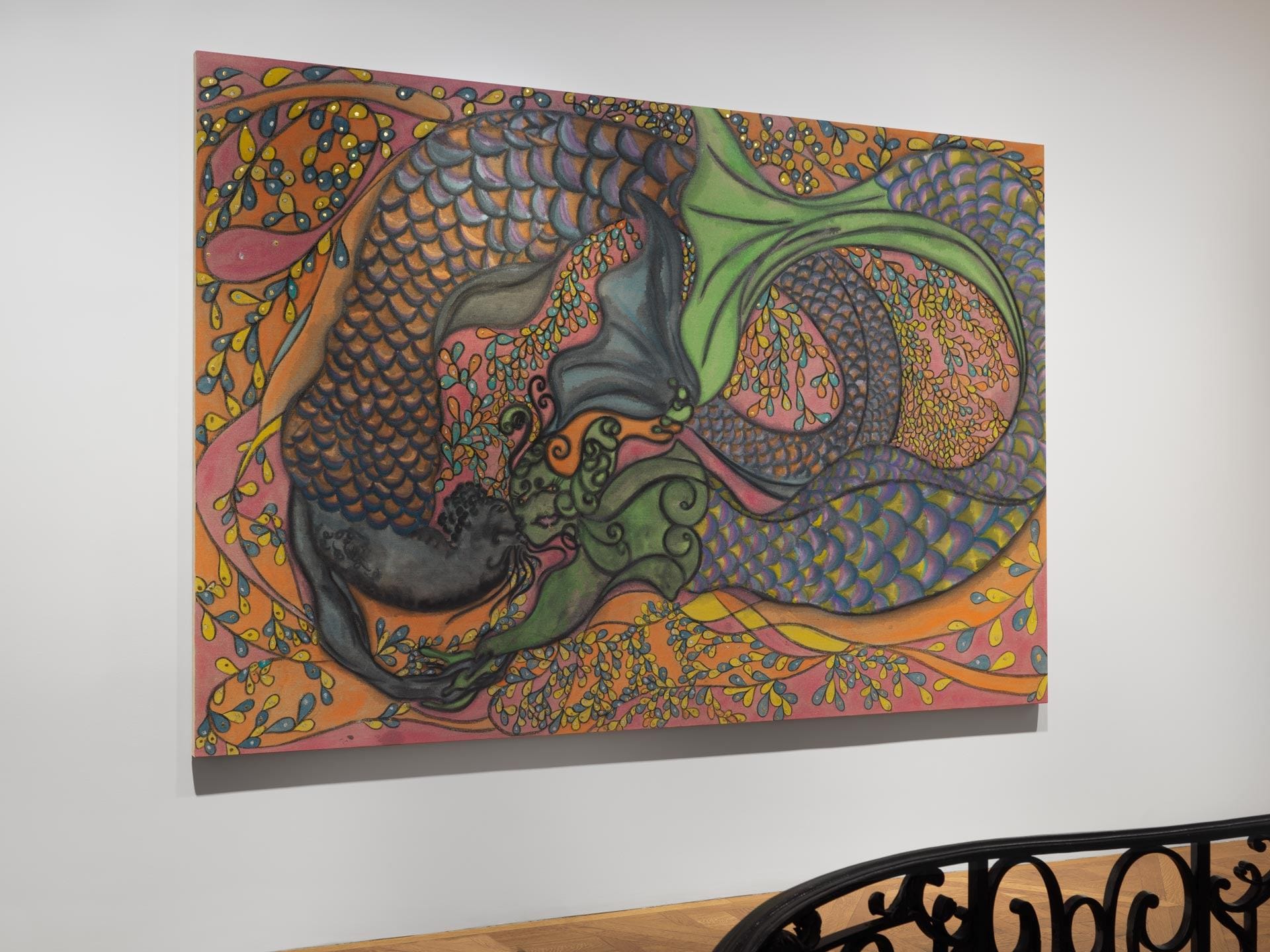 Colorful abstract painting of two intertwined fish with intricate patterns and vibrant background hanging on a gallery wall.