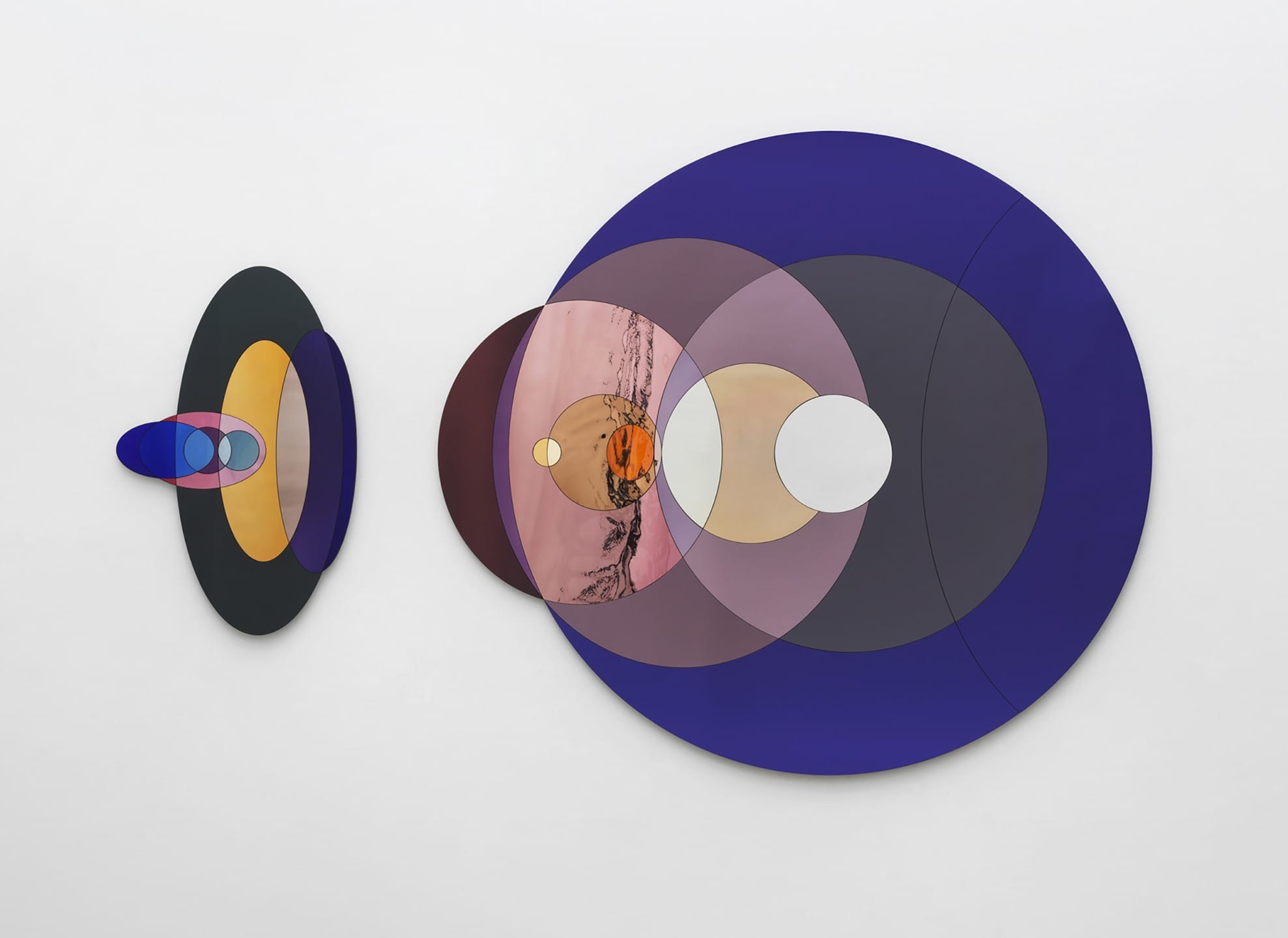 Abstract wall art with overlapping colored circles in shades of blue, purple, pink, and black on a white background.