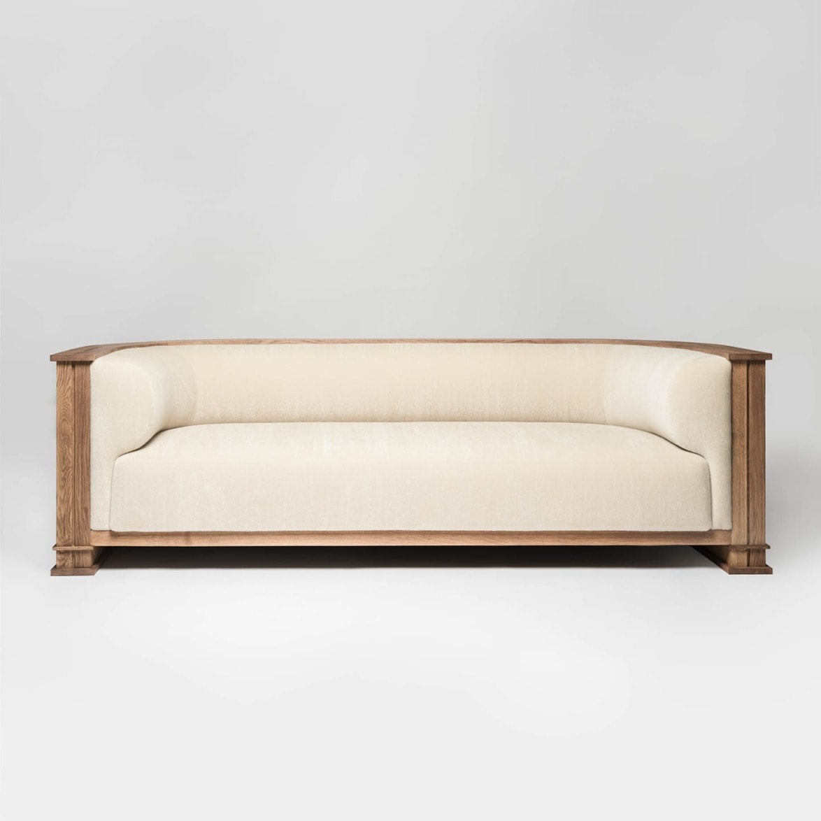 Cream-colored wooden frame sofa with soft cushions against a plain white background.