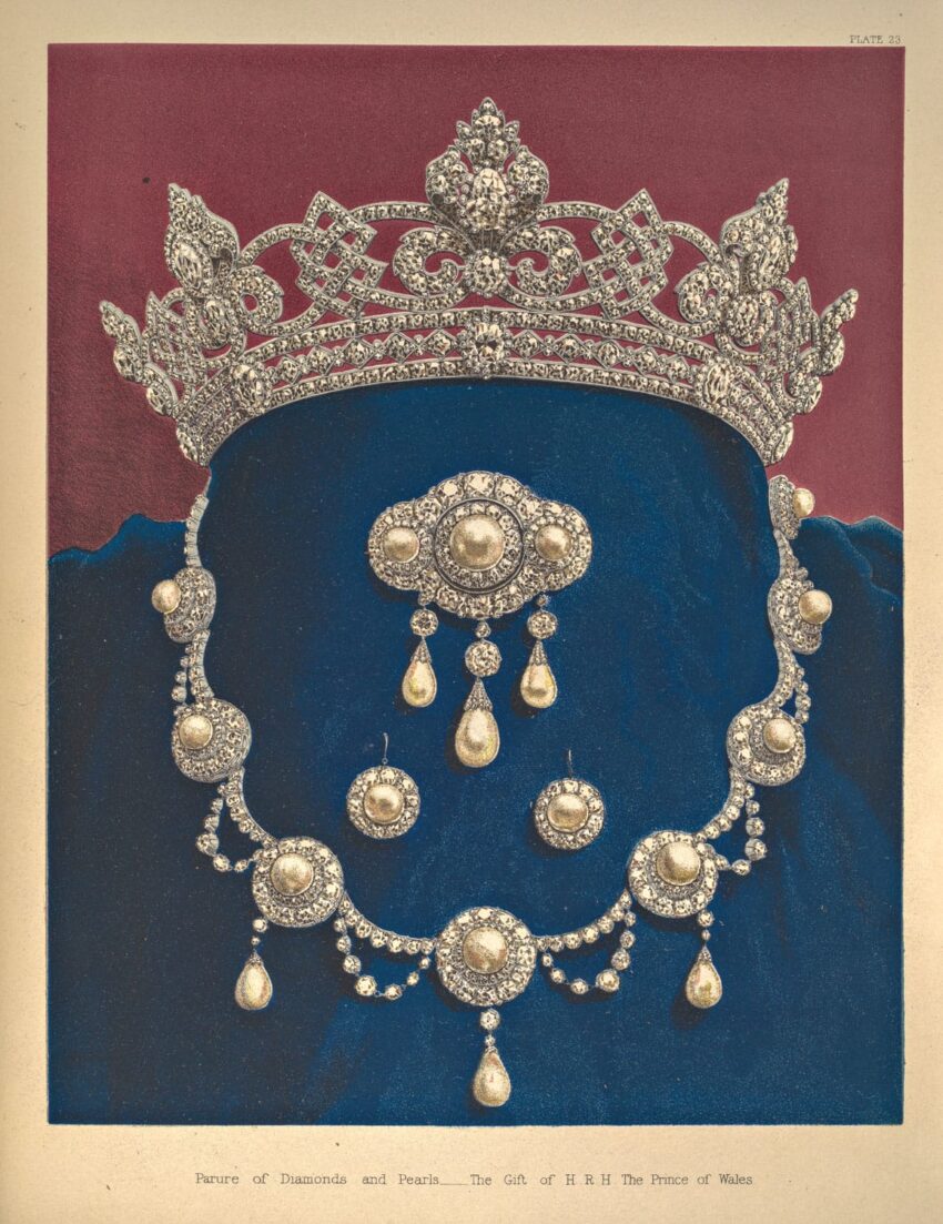 Elegant diamond and pearl tiara and necklace set displayed on blue velvet background.