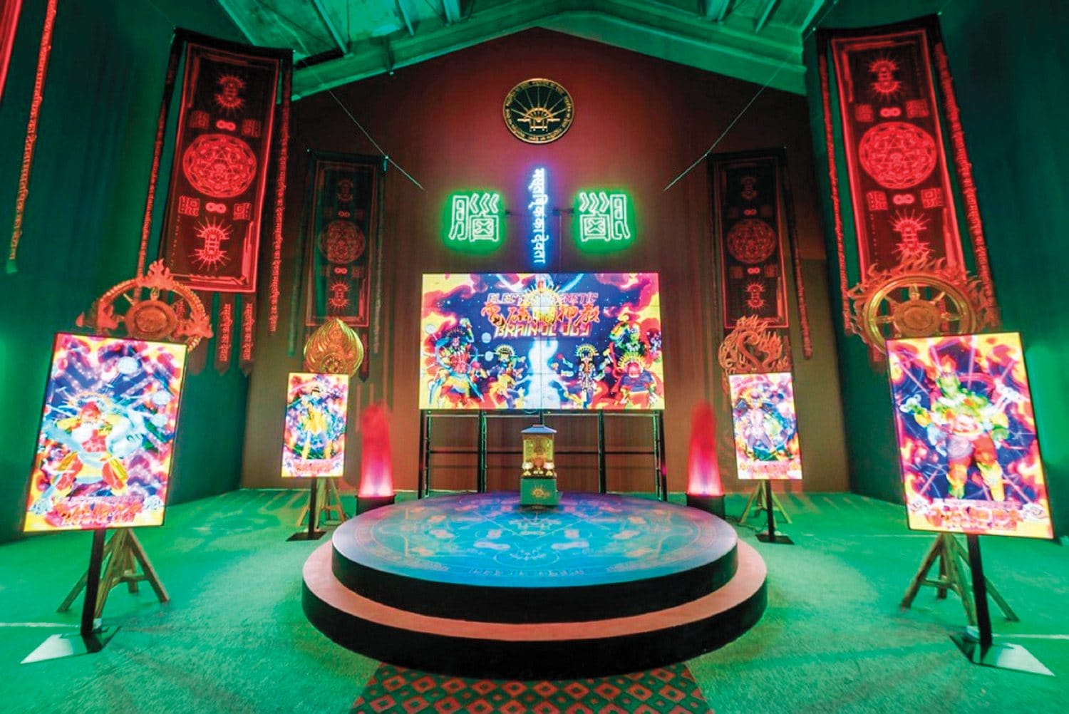 Colorful room with neon signs and vibrant art displays on stands in a circular arrangement.