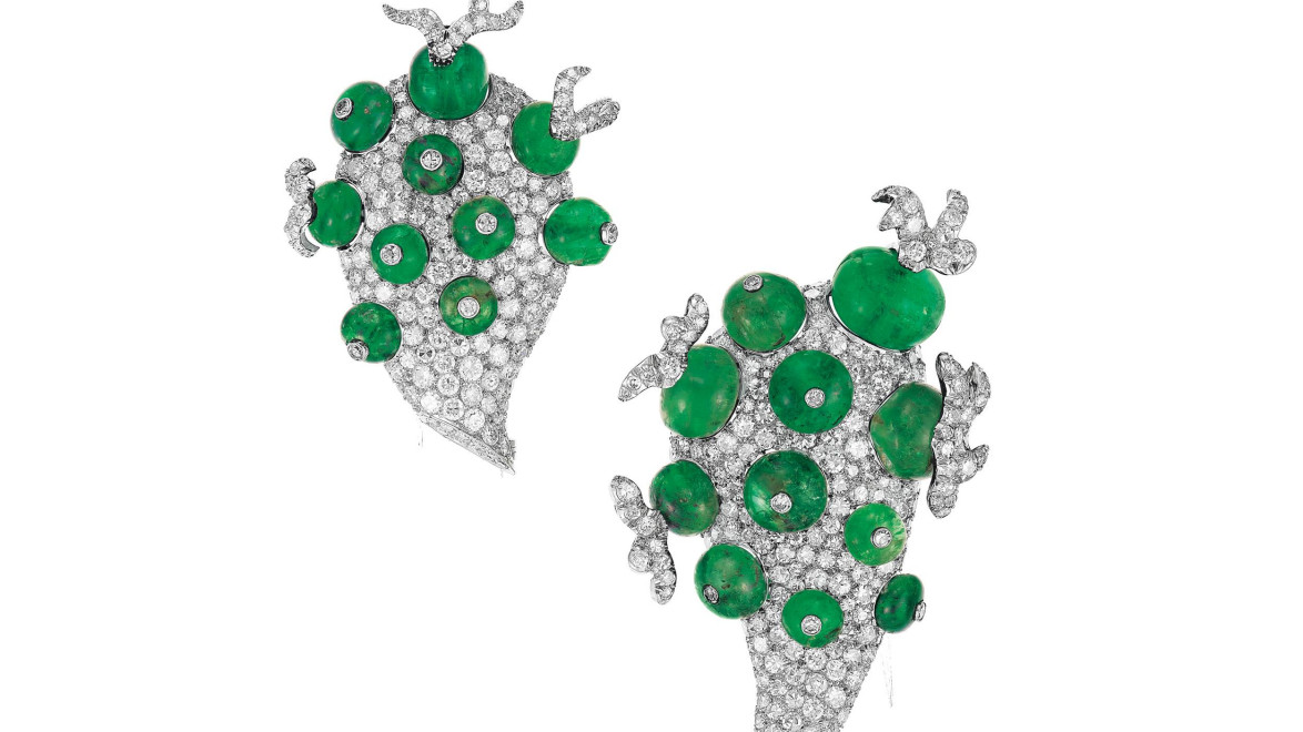 Emerald and diamond earrings with intricate design featuring green gemstones and sparkling accents set in silver.