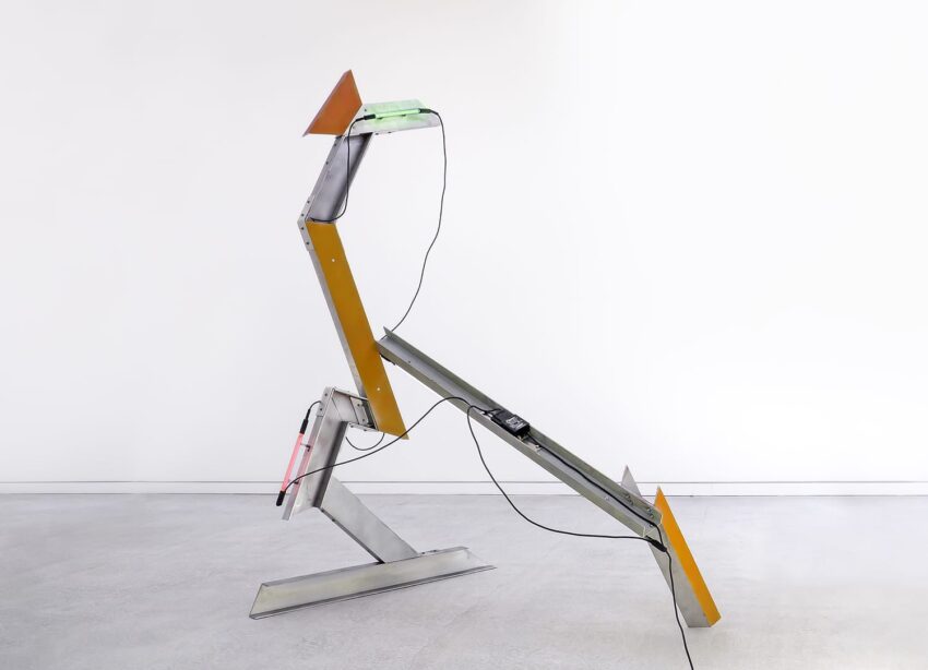 Abstract metal sculpture with angular shapes, featuring wires and a geometric design, set against a minimalist background.