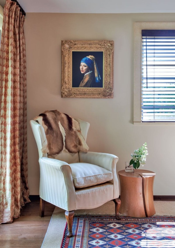 Elegant room with an armchair, wooden side table, and a painting on the wall.