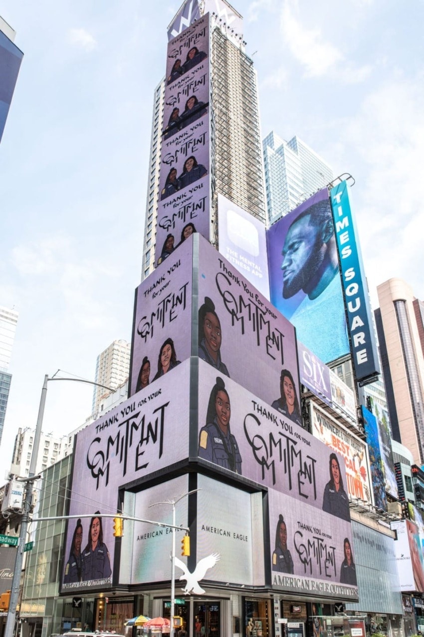 Times Square building with multiple digital billboards showing art and advertisements, including "Thank You for Joining the Eminent."