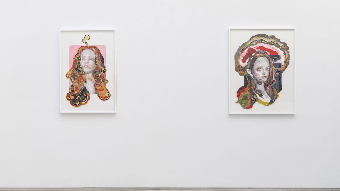 Two colorful abstract portraits in white frames on a white gallery wall.