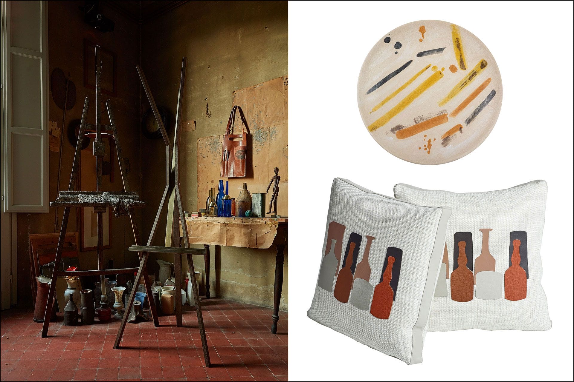 Artist's studio with easels, art supplies, two pillows with bottle designs, and a decorative plate with brushes and colors.