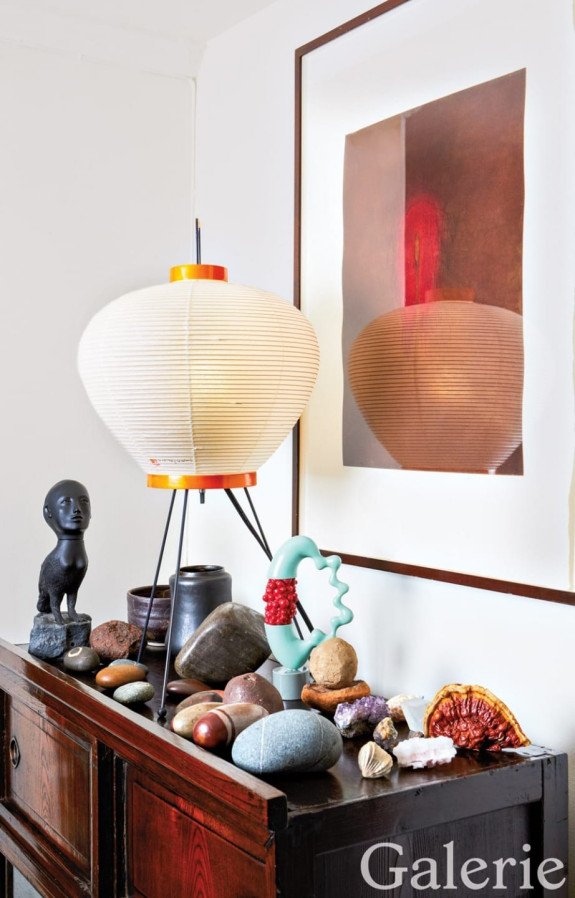 An Anish Kapoor etching backs a table adorned with a Kiki Smith sculpture, a Isamu Noguchi lamp, a George Ohr ceramic work, and various stones that were a gift from Joan Jonas.
