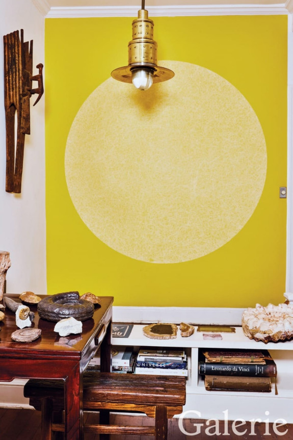 A wall drawing by Sol LeWitt brings color to the living room, which is adorned with a Bambara elephant and monkey mask from Africa and a collection of fossils.