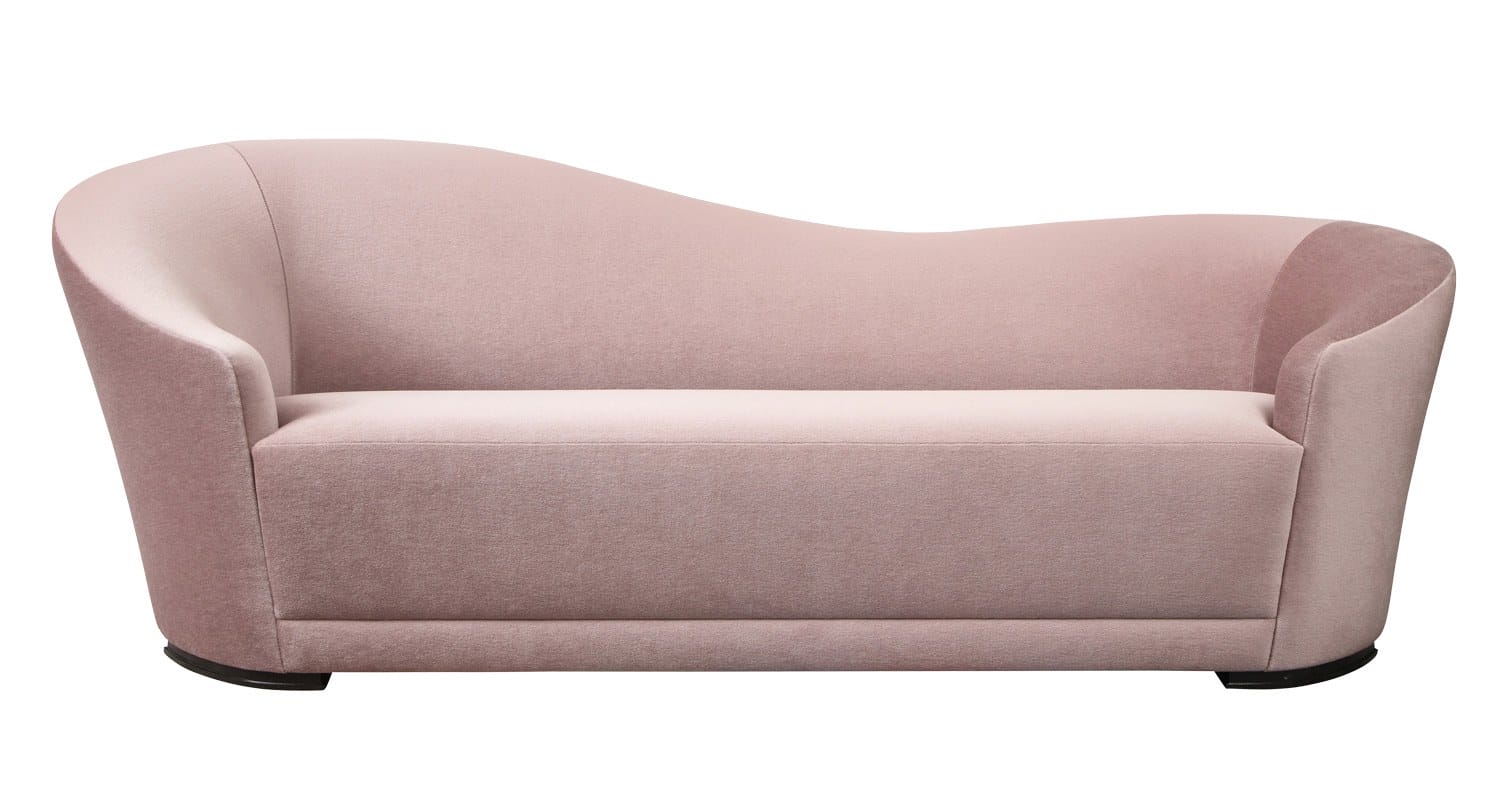 Curved pink velvet sofa with rounded back and armrests on a white background.