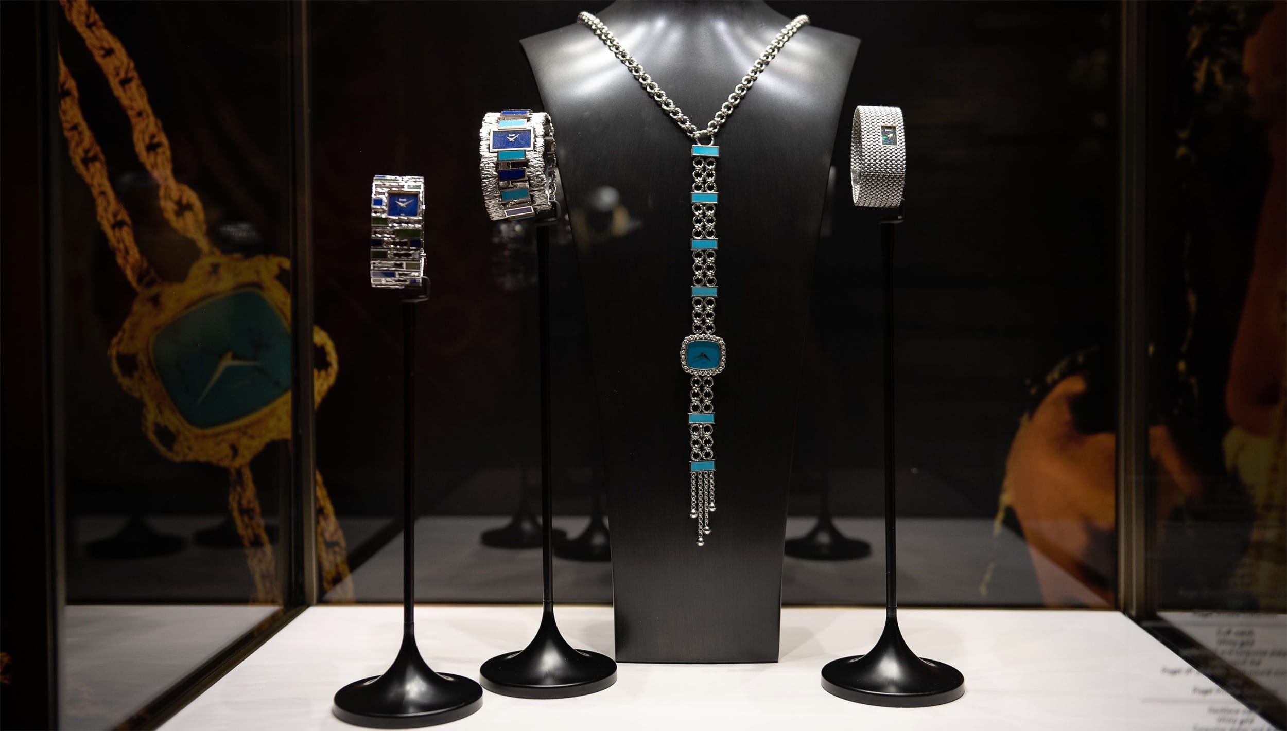 Exquisite jewelry set including necklaces and bracelets displayed on stands against a dark background.