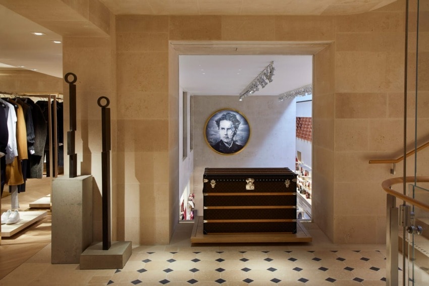 Luxury boutique interior featuring stylish decor, including a portrait and a designer trunk on display.