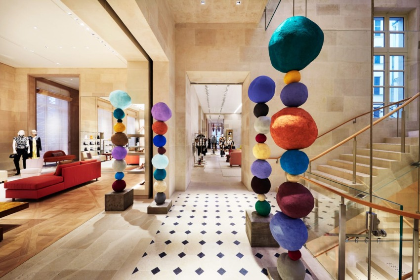 Colorful abstract sculptures in a modern retail store interior with mannequins and stylish furniture.