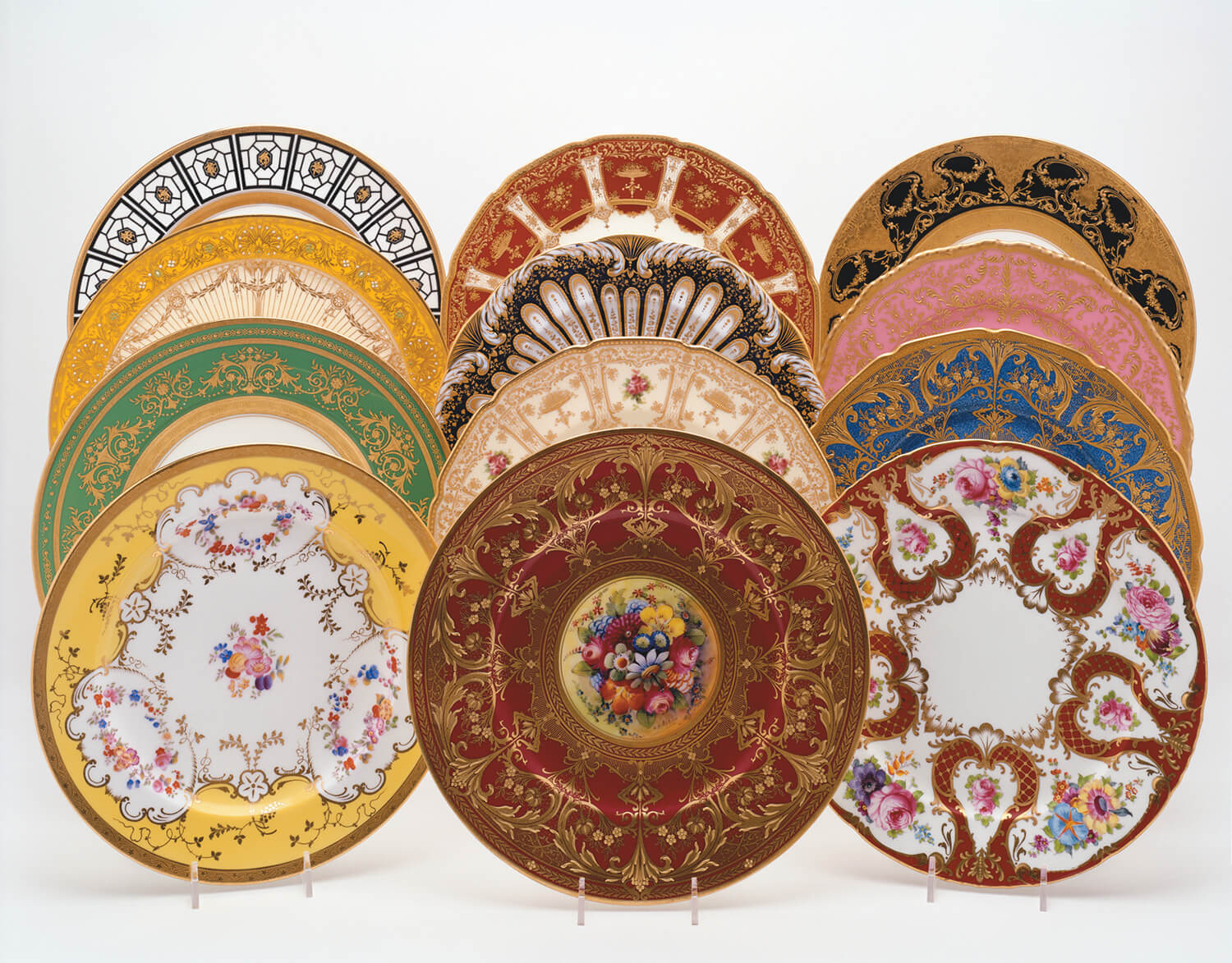 Collection of ornate and colorful porcelain plates with intricate floral and geometric designs displayed upright.