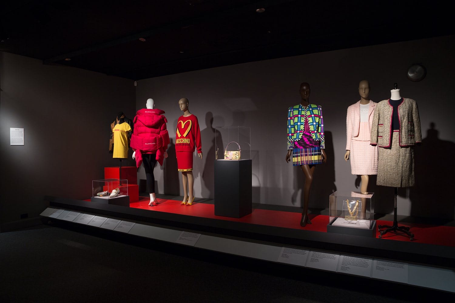 Installation view of "Power Mode: The Force of Fashion" at the Museum at FIT which includes designs from Gucci, Balenciaga, Fendi, and Chanel.