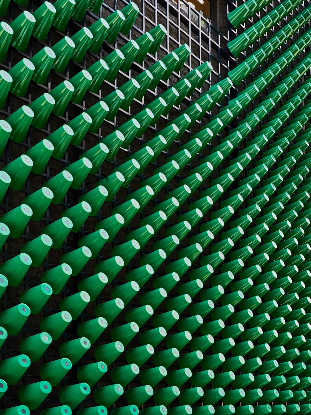 Rows of green traffic cones arranged in a pattern against a grid background.