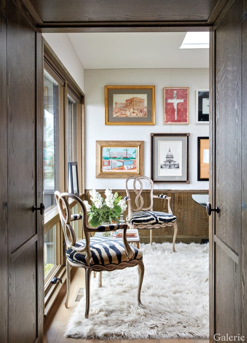 Cozy sitting area with elegant chairs, wall art, and a plush white rug by a window.