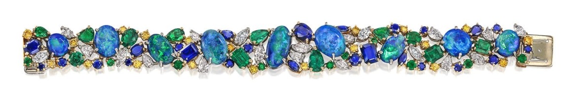 Colorful gemstone bracelet with various blue, green, and yellow stones set in an intricate design.