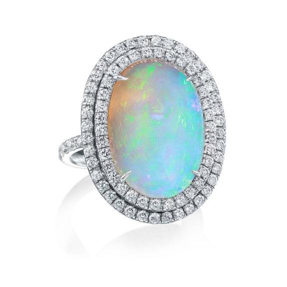 Elegant opal ring encircled by two rows of sparkling diamonds set in a sleek silver band.