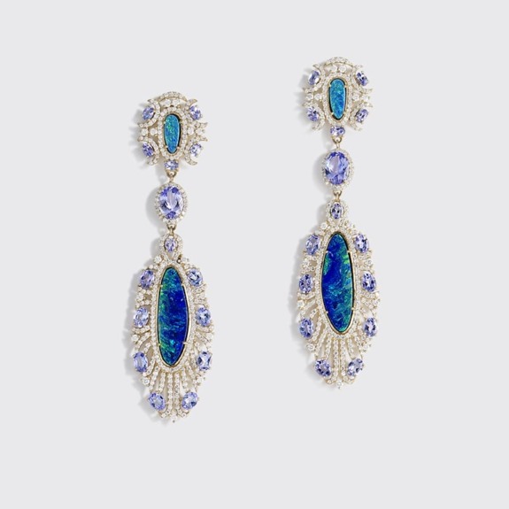 Elegant silver earrings adorned with blue and purple gemstones on a plain background.