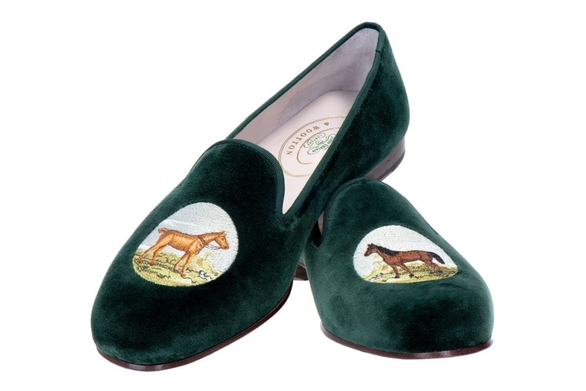 Green velvet shoes with horse embroidery on top.