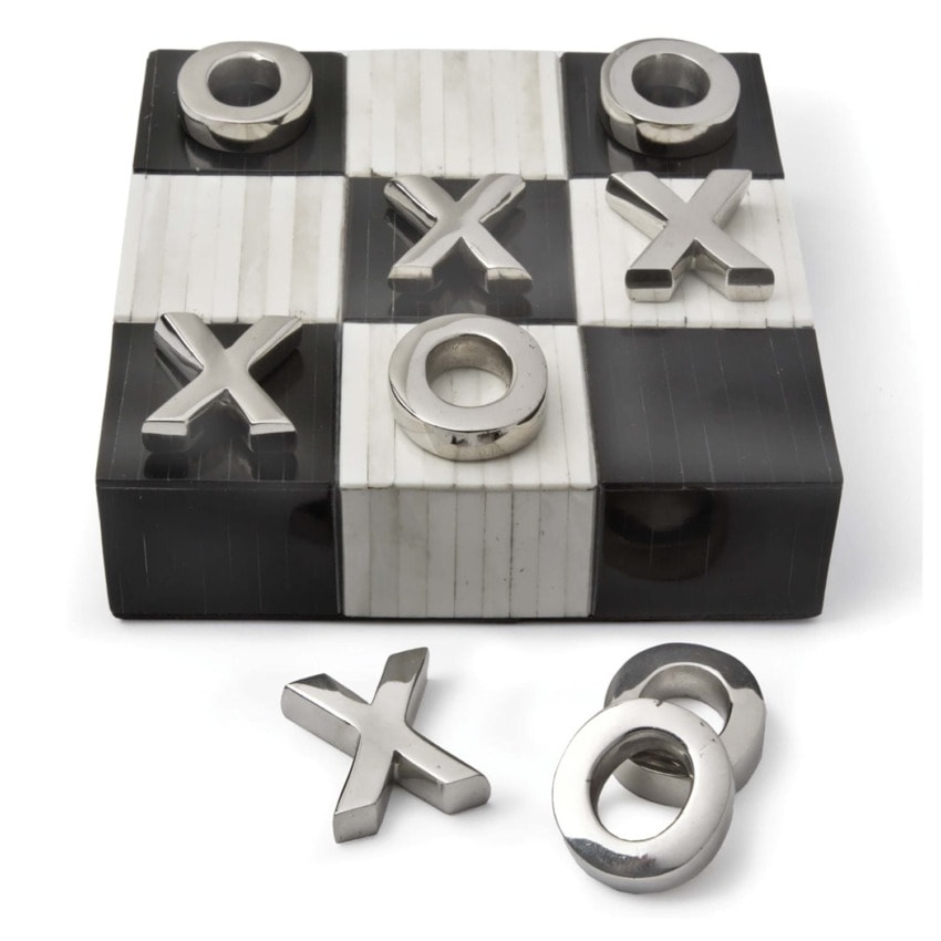 Tic-tac-toe board with metallic X and O pieces on a black and white checkered surface, some pieces placed and some off the board.