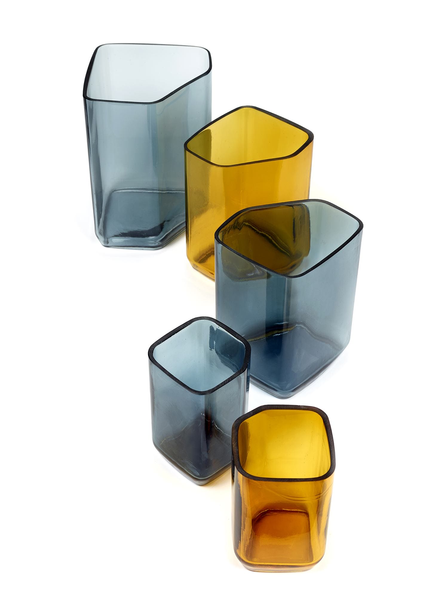 Set of five modern geometric glass vases in shades of blue and amber arranged on a white background.