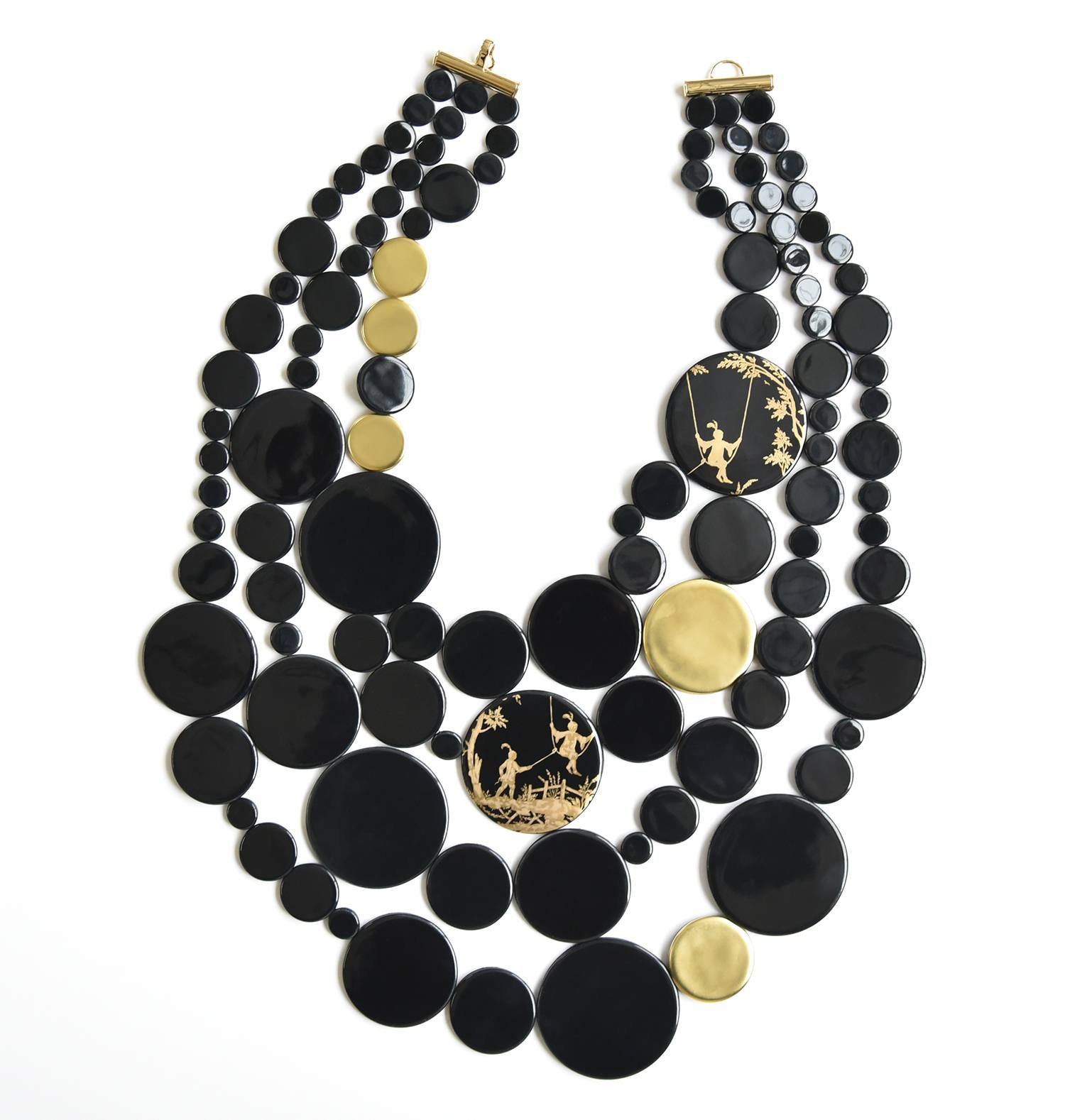 Triple-strand black and gold statement necklace with circular beads and detailed design featuring animals and trees.