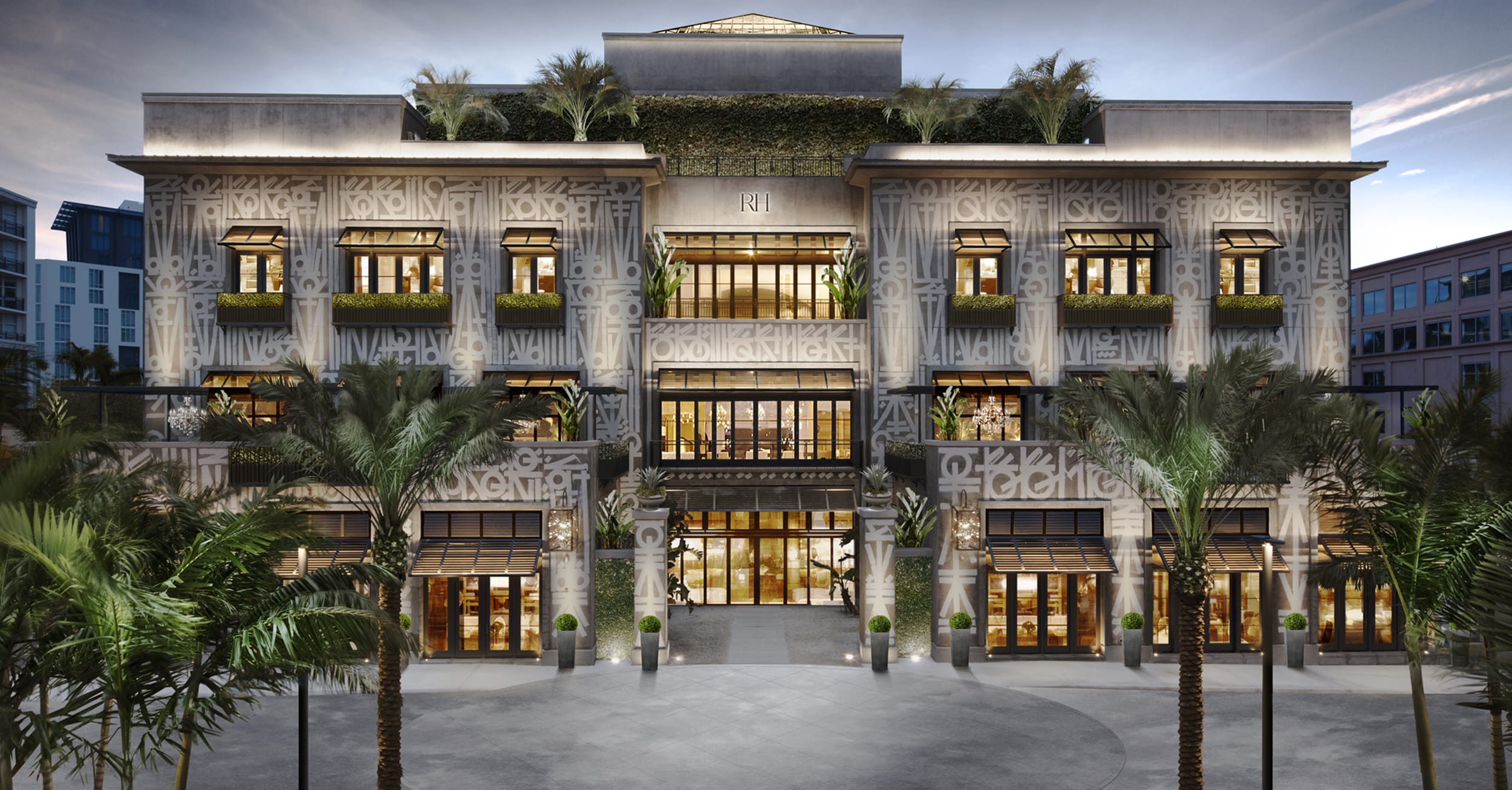 Elegant multi-story building with lush greenery, large windows, and decorative facade, surrounded by palm trees at sunset.