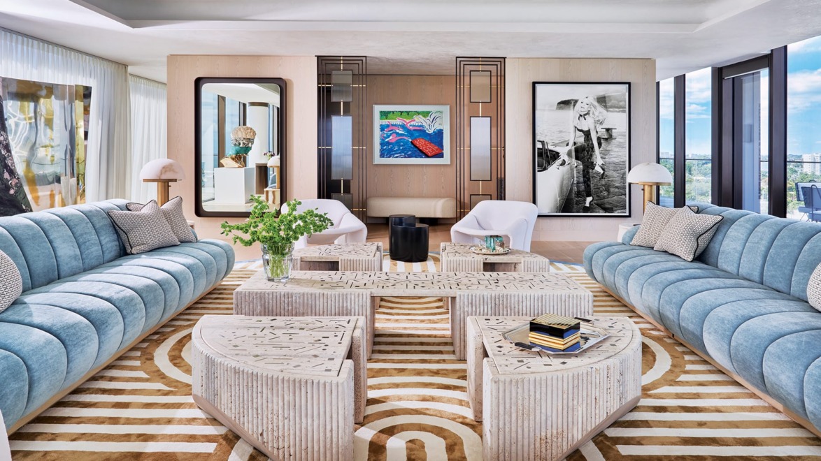 One of David Hockney's colorful pool lithographs hangs in the entry, framed by bronze-and-glass screens by Torrey, who also designed the living room's sofas, the rug made by Stark, and the mirror that hangs across from an Ellen von Unwerth photograph of model Claudia Schiffer. The multipart David/Nicolas table was a custom commission, a pair of vintage Pierre Paulin lounge chairs flank an Eric Schmitt bronze side table from Ralph Pucci, the lamps are by RH, and Vincenzo de Cotiis conceived the standing screen at left.