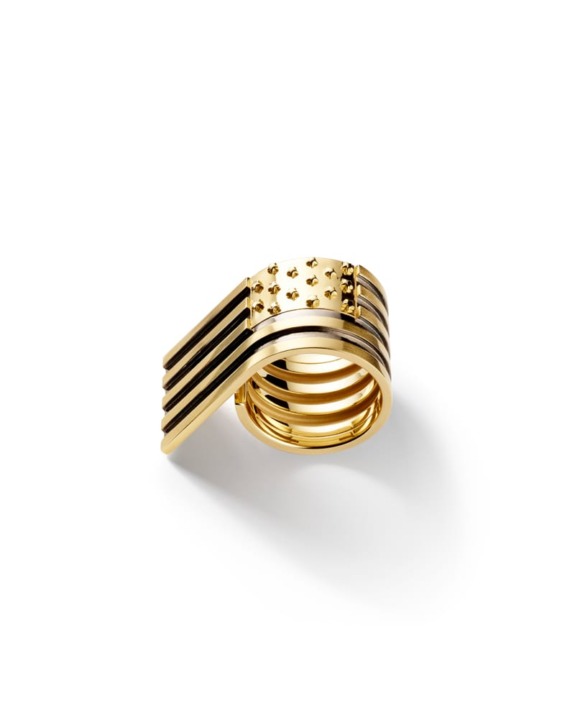 Gold ring with unique geometric design featuring parallel lines and studded details on a white background.