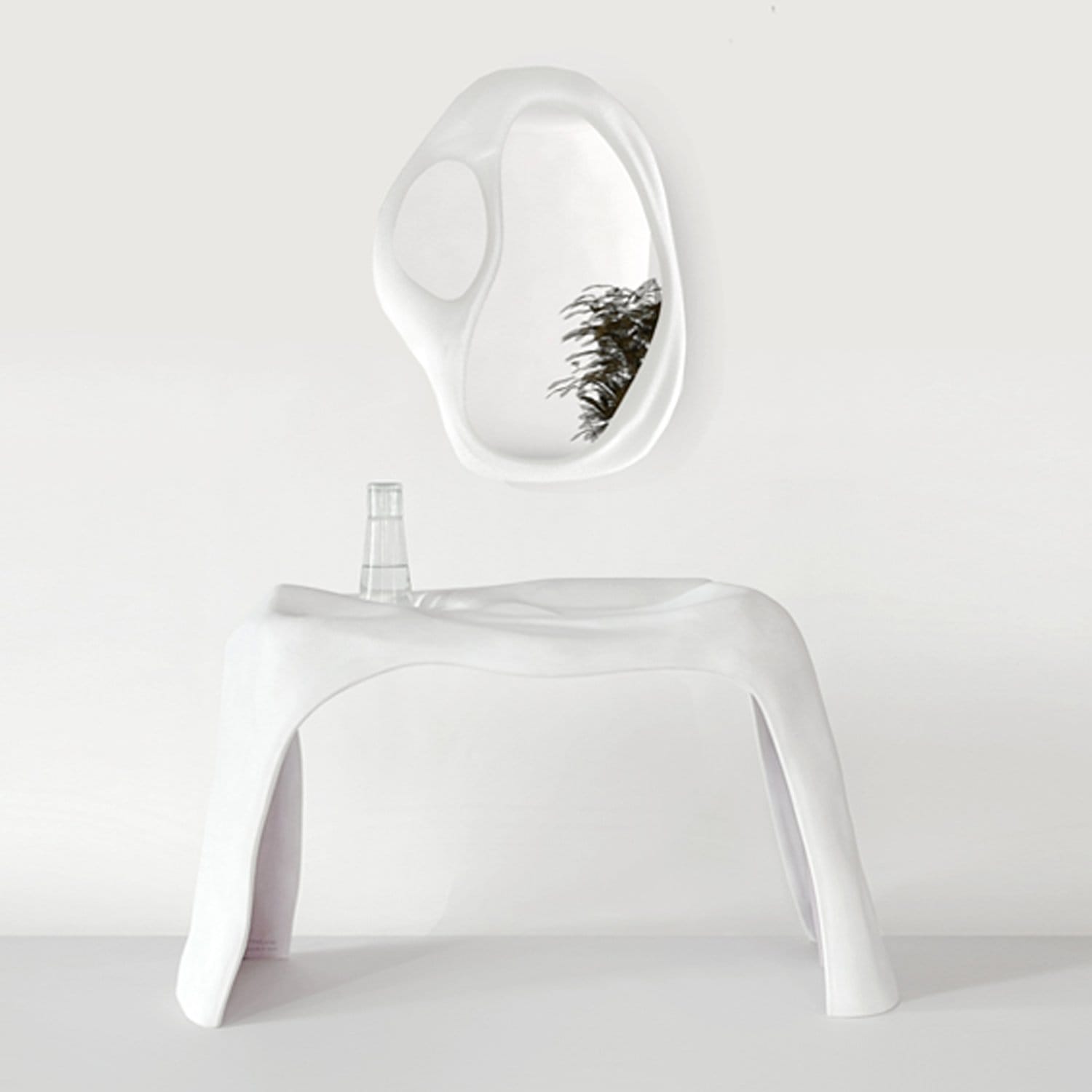 Modern white sculptural table with a unique, curved mirror above, reflecting a plant.