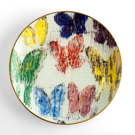 Decorative plate with colorful butterfly patterns on a textured background.