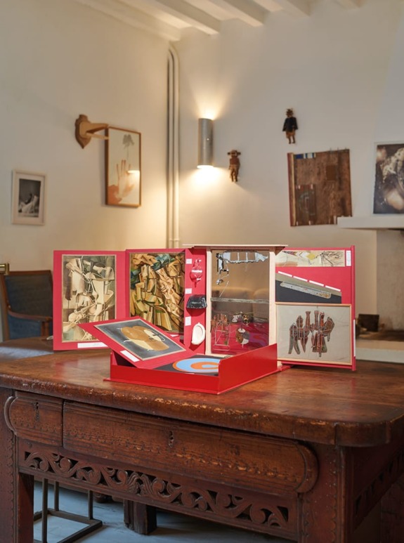 Art book displayed on a wooden table in a cozy room with framed wall art and vintage decor.