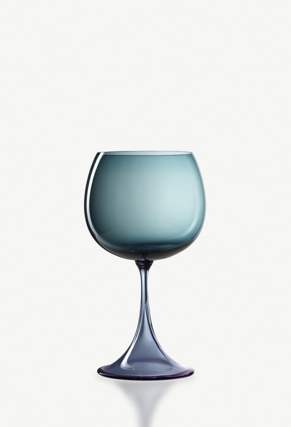 Blue tinted wine glass with a wide bowl and slender stem on a white background