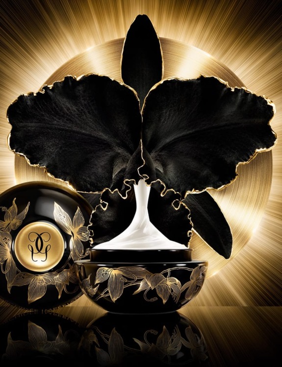 Luxurious black and gold cosmetic jar with ornate floral design, set against a radiant golden background.
