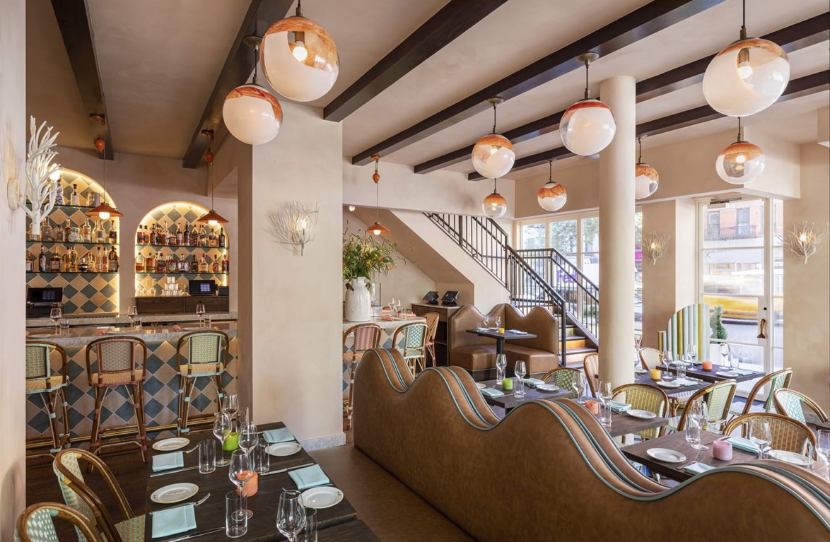 Modern restaurant interior with stylish lighting, cozy seating, and a set dining table, creating an inviting atmosphere.