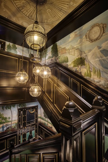 A scenic mural painted by decorative artists Croxford and Saunders envelopes the stately staircase at new Edinburgh hotel 100 Princes Street.