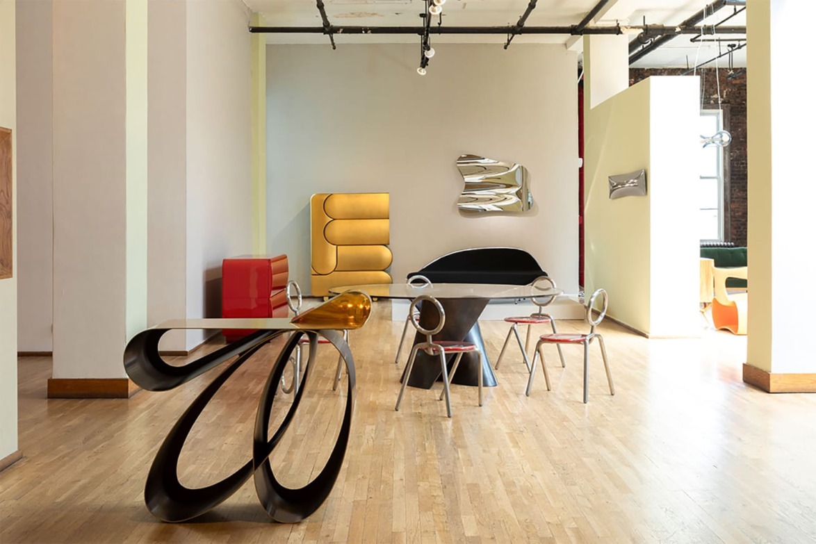 Modern art gallery with abstract sculptures and contemporary furniture on a wooden floor.